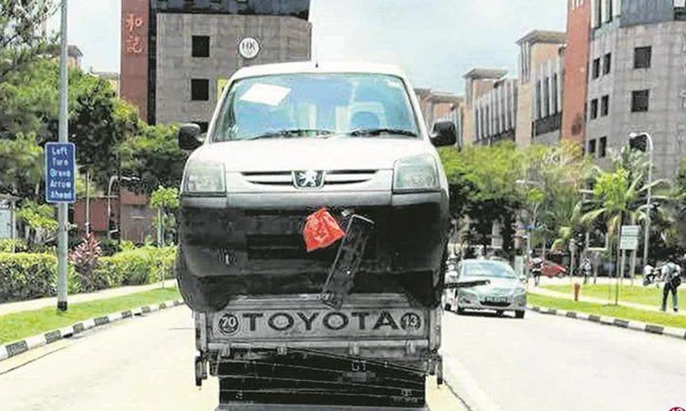 Peugeot 'hitches ride' on lorry's back at Kaki Bukit Ave 3: Car was unsteady with two wheels dangling outside