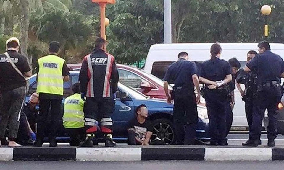 The arrested man, who allegedly wielded an electroshock weapon, is seen sitting on the road flanked by police and SCDF officers. Police investigations are ongoing in the case, the latest in a spate of incidents involving drivers of rental cars.PHOTO: SHIN MIN DAILY NEWS READER