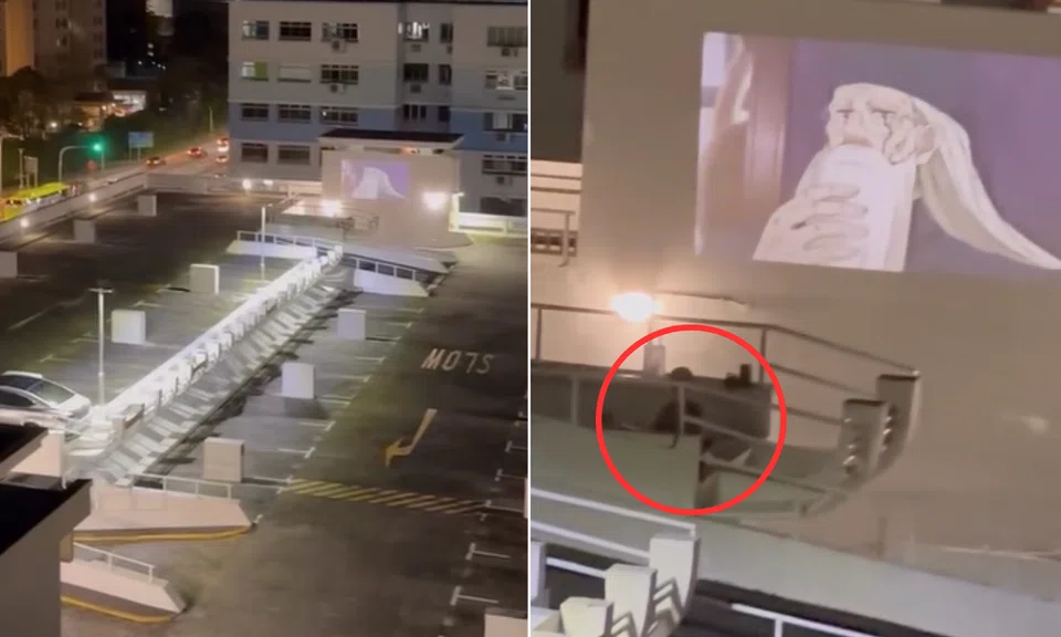 man uses projector to watch anime at heartland carpark