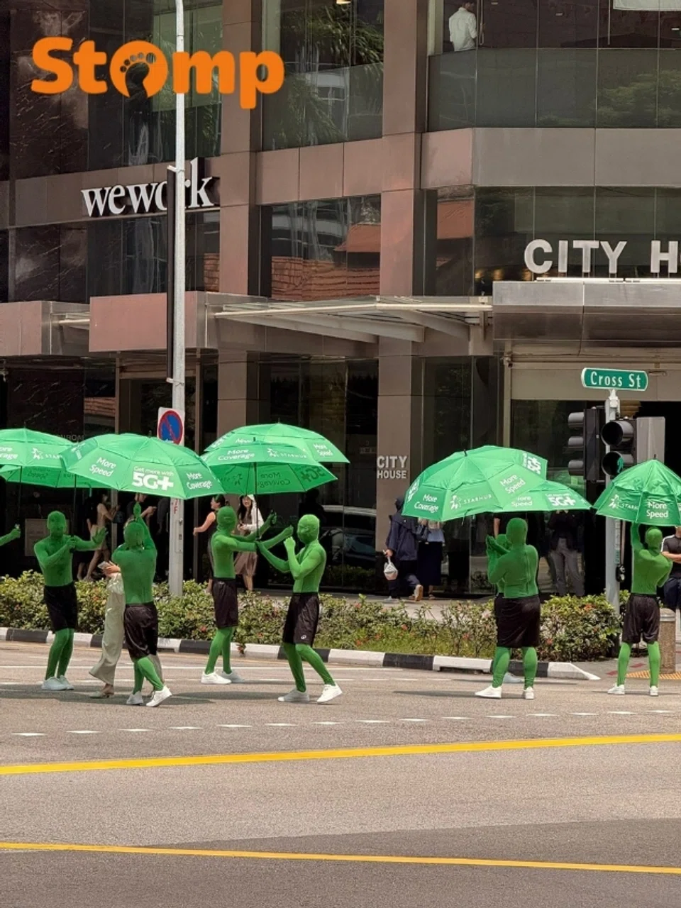 ‘Green men’ hold up umbrellas for people at Lau Pa Sat