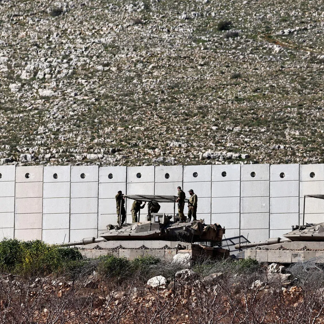 FILE PHOTO: Israeli soldiers work on their tank on the Israeli side of the Israel-Lebanon border, amid escalation between Hezbollah and Israel, and amid the U.S.-Israeli conflict with Iran, in northern Israel, March 10, 2026. REUTERS/Amir Cohen/File Photo