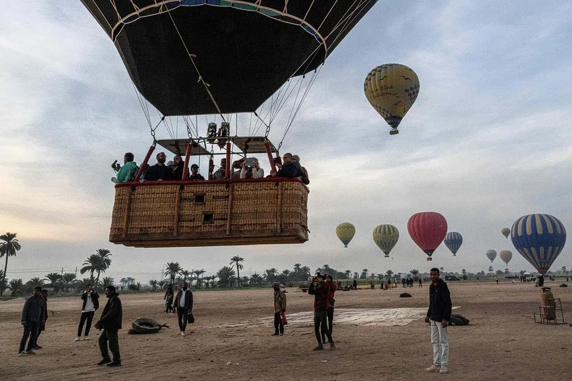 A hot air balloon taking off with tourists in its basket in Egypt's southern city of Luxor on Jan 9, 2025. 