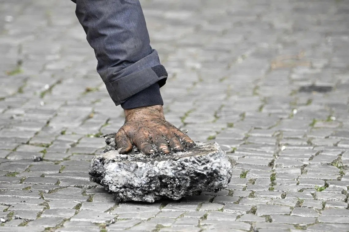 A close-up on the hand of an activist that is glued on a piece of concrete after police removed him from the road.