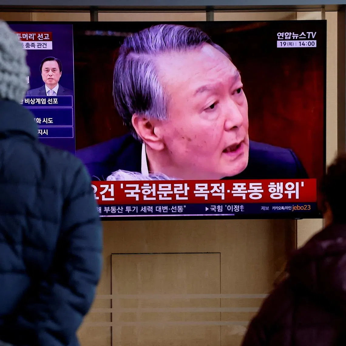 People watch a news report on the sentencing trial of South Korean former president Yoon Suk Yeol's insurrection case, stemming from his short-lived declaration of martial law in December 2024, in Seoul, South Korea, February 19, 2026. REUTERS/Kim Soo-hyeon/File Photo