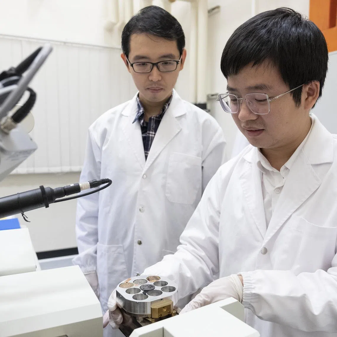 jtquantum13 - Nanyang Asst Prof Wong Liang Jie (left) and research fellow Dr Huang Sunchao from Nanyang Technological University, Singapore loading a sample intoascanning electron microscope used in their quantum recoil experiments.



Credit: NTU Singapore