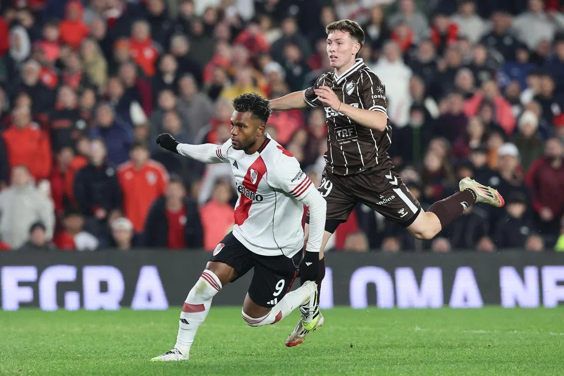 River Plate's Colombian forward Miguel Borja firing past Platense midfielder Franco Minerva for his team's third goal in the Argentine Professional Football League Clausura Tournament at the Monumental Stadium in Buenos Aires on July 13, 2025.