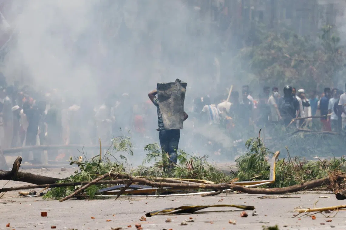 FILE PHOTO: A protester covers himself with a metal sheet during a clash with Border Guard Bangladesh (BGB) and the police outside the state-owned Bangladesh Television as violence erupts across the country after anti-quota protests by students, in Dhaka, Bangladesh, July 19, 2024. REUTERS/Mohammad Ponir Hossain/File Photo