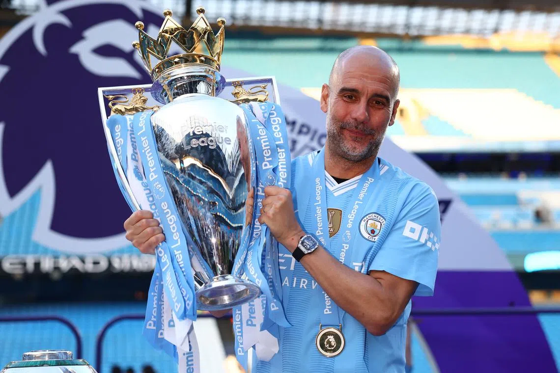 Soccer Football - Premier League - Manchester City v West Ham United - Etihad Stadium, Manchester, Britain - May 19, 2024  Manchester City manager Pep Guardiola celebrates with the trophy after winning the Premier League REUTERS/Molly Darlington