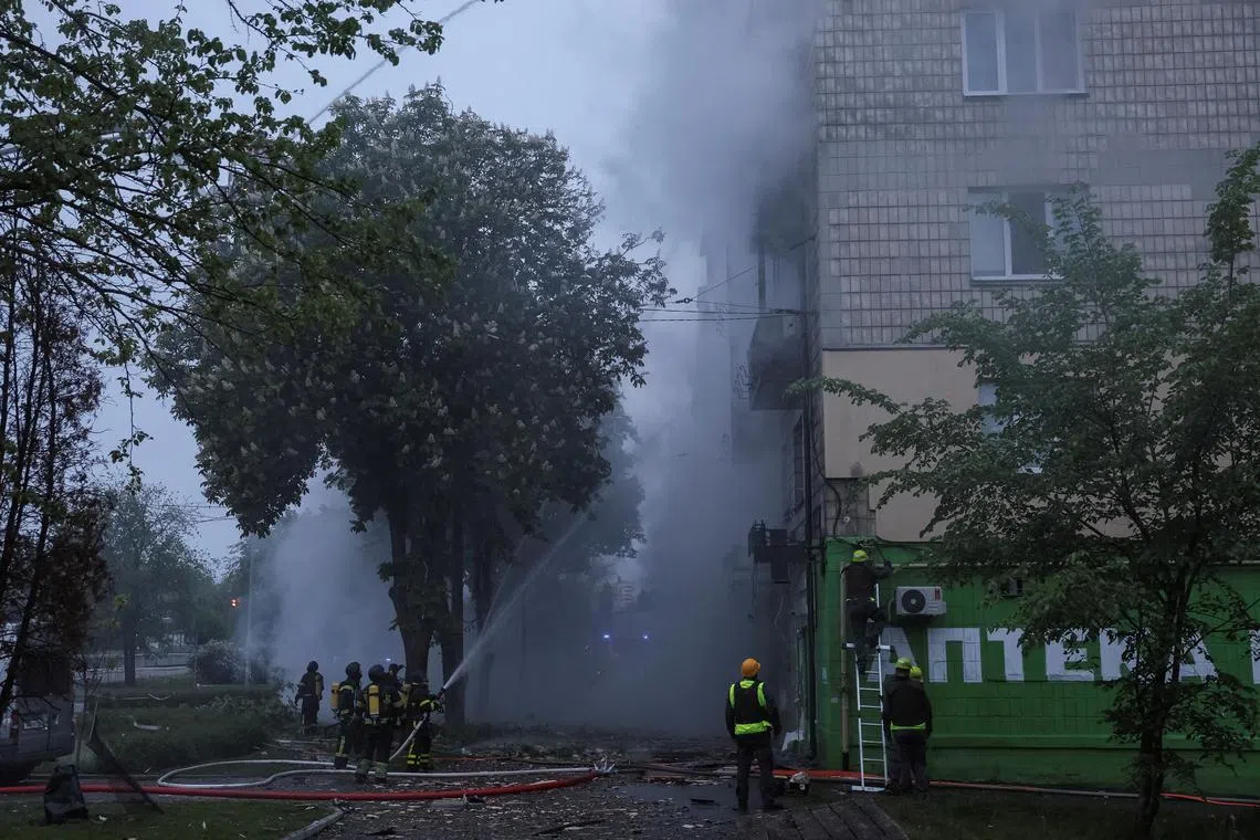 Firefighters work at the site an apartment building hit by a Russian drone strike, amid Russia's attack on Ukraine, in Kyiv, Ukraine May 7, 2025. REUTERS/Gleb Garanich