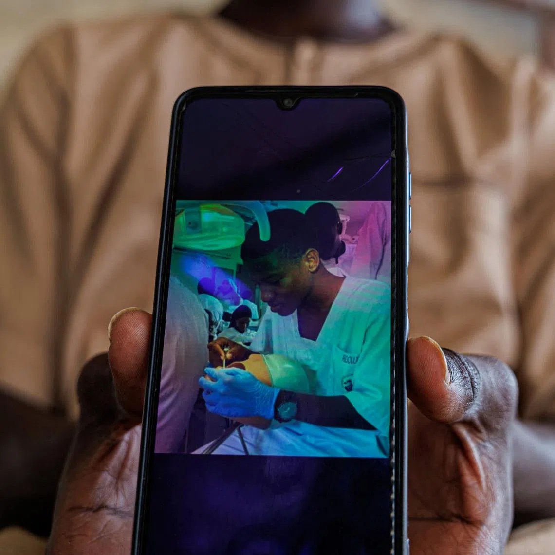 A brother of Abdoulaye Ba, a student who, according to other students, was killed at the Cheikh Anta Diop University (UCAD) campus during protests over financial aid that turned violent, shows Abdoulaye's photo on his mobile phone at their house in Dakar, Senegal, February 12, 2026. REUTERS/Zohra Bensemra