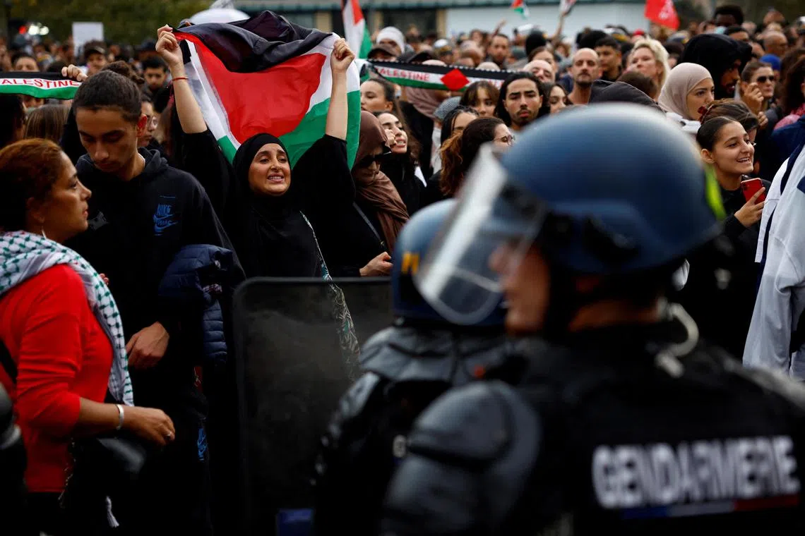 French gendarmes surround protesters holding Palestinian flags, during an unauthorised demonstration in Paris.