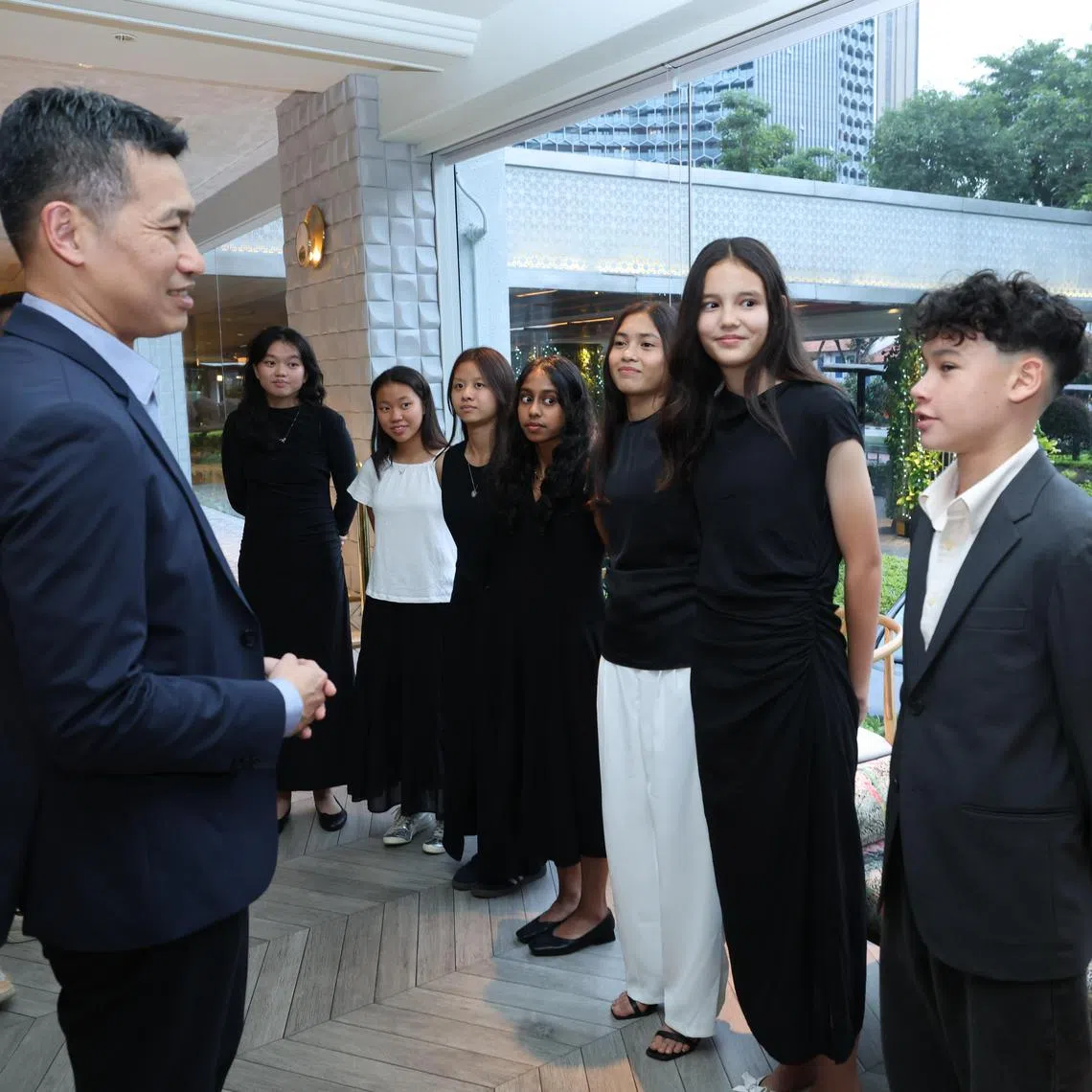 Acting Minister for Culture, Community and Youth David Neo (left) speaking to Edan McCulloch (extreme right) ahead of the UTR scholarship award ceremony.