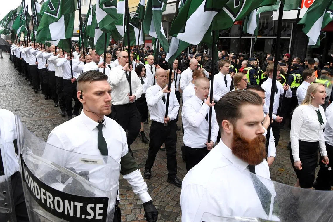 FILE PHOTO: Members of the Neo-nazi Nordic Resistance Movement march through the town of Ludvika, Sweden May 1, 2018. The march was opposed by anti-fascist groups and the local police, reinforced from other parts of Sweden, kept the groups apart.  Ulf Palm/TT News Agency/via REUTERS/File Photo