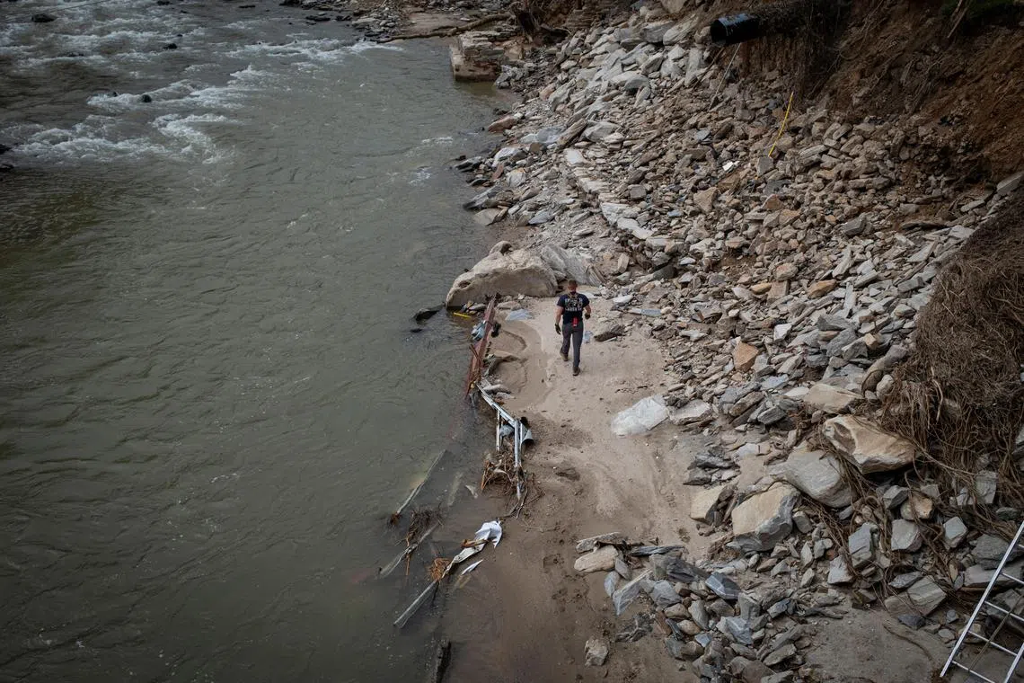 A Fire and Rescue member walks on Broad River riverbank, following the passing of Hurricane Helene, in Bat Cave, North Carolina, U.S., September 30, 2024. REUTERS/Marco Bello
