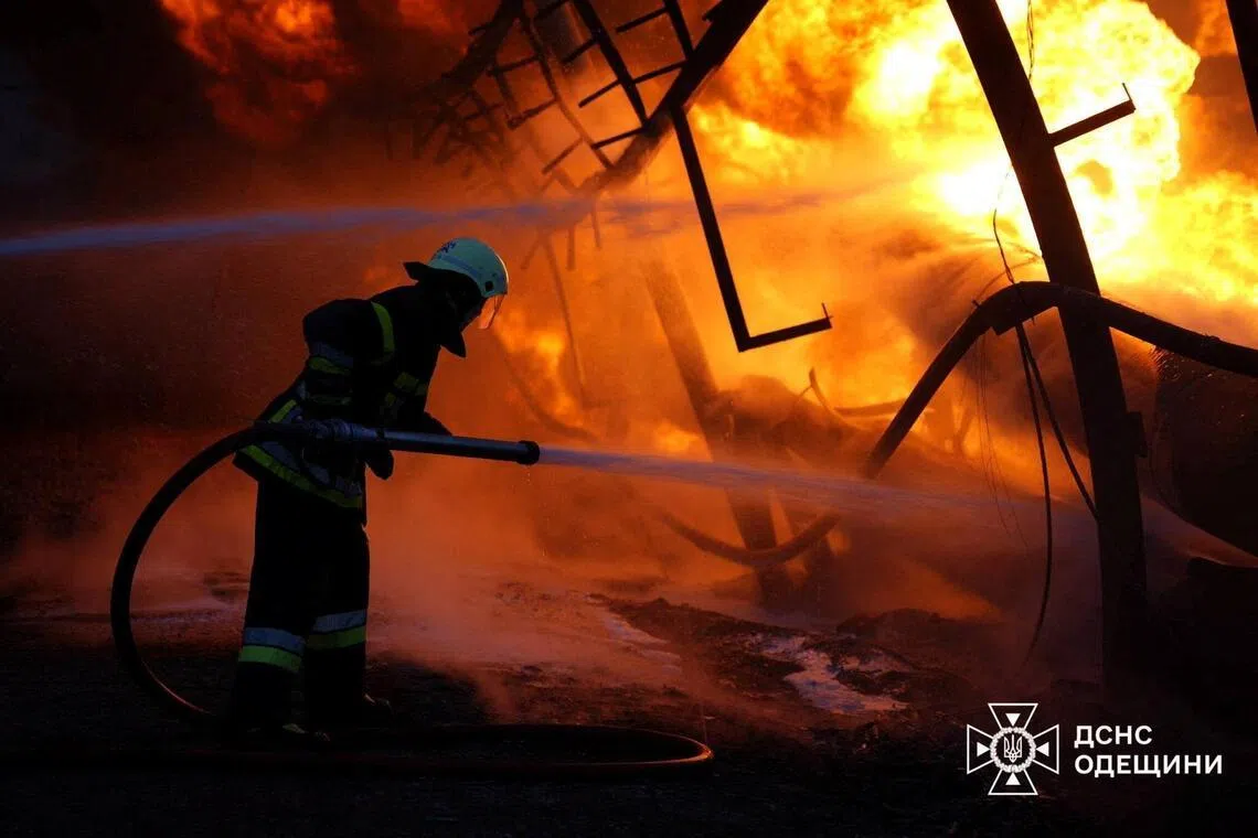 A firefighter tries to put out fire at a critical infrastructure facility hit by Russian drone strikes in Odesa region, Ukraine.