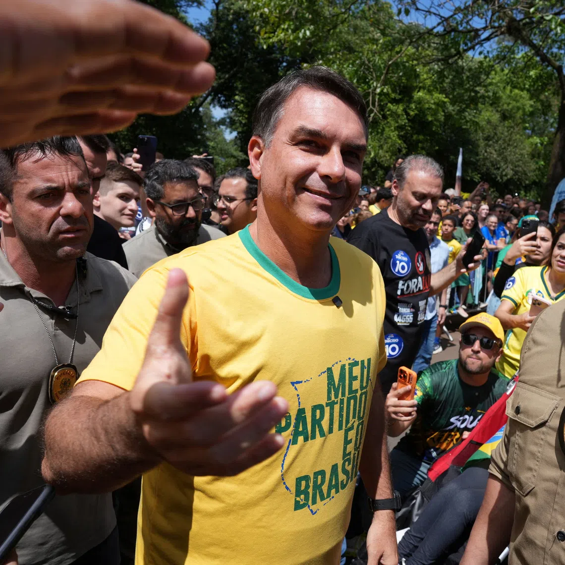 Brazilian presidential candidate Flavio Bolsonaro of the Liberal Party greets people during a campaign rally, one day before the general election, in Santa Barbara do Oeste, Brazil.