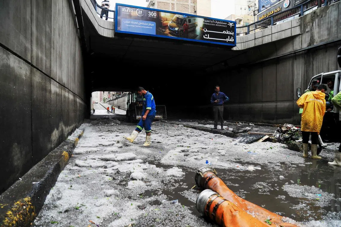 Municipal emergency service staff clear hail blocking an underpass after a windstorm struck Egypt's northern city of Alexandria on the Mediterranean coast in the early hours on May 31, 2025. (Photo by Hazem GOUDA / AFP)
