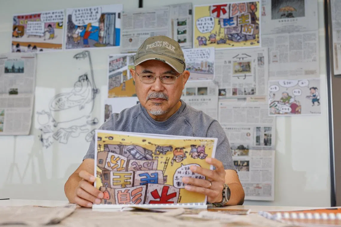 Cartoonist Wong Kei-kwan poses for photos after his comic strip was scrapped from the newspaper Ming Pao in Hong Kong.