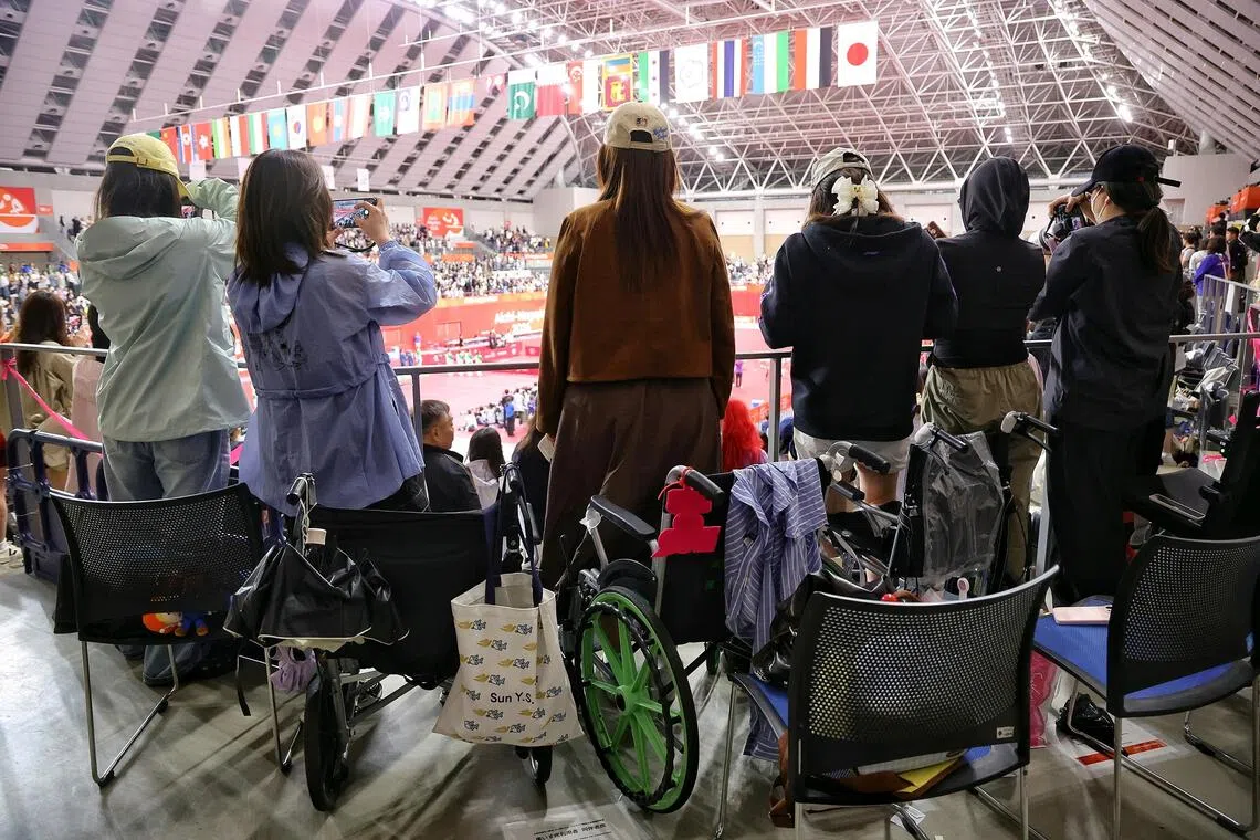 A group of Chinese table tennis fans standing up from their wheelchairs for China’s national anthem during the Aichi-Nagoya Asian Games table tennis women’s doubles and men’s singles finals on Sept 28.