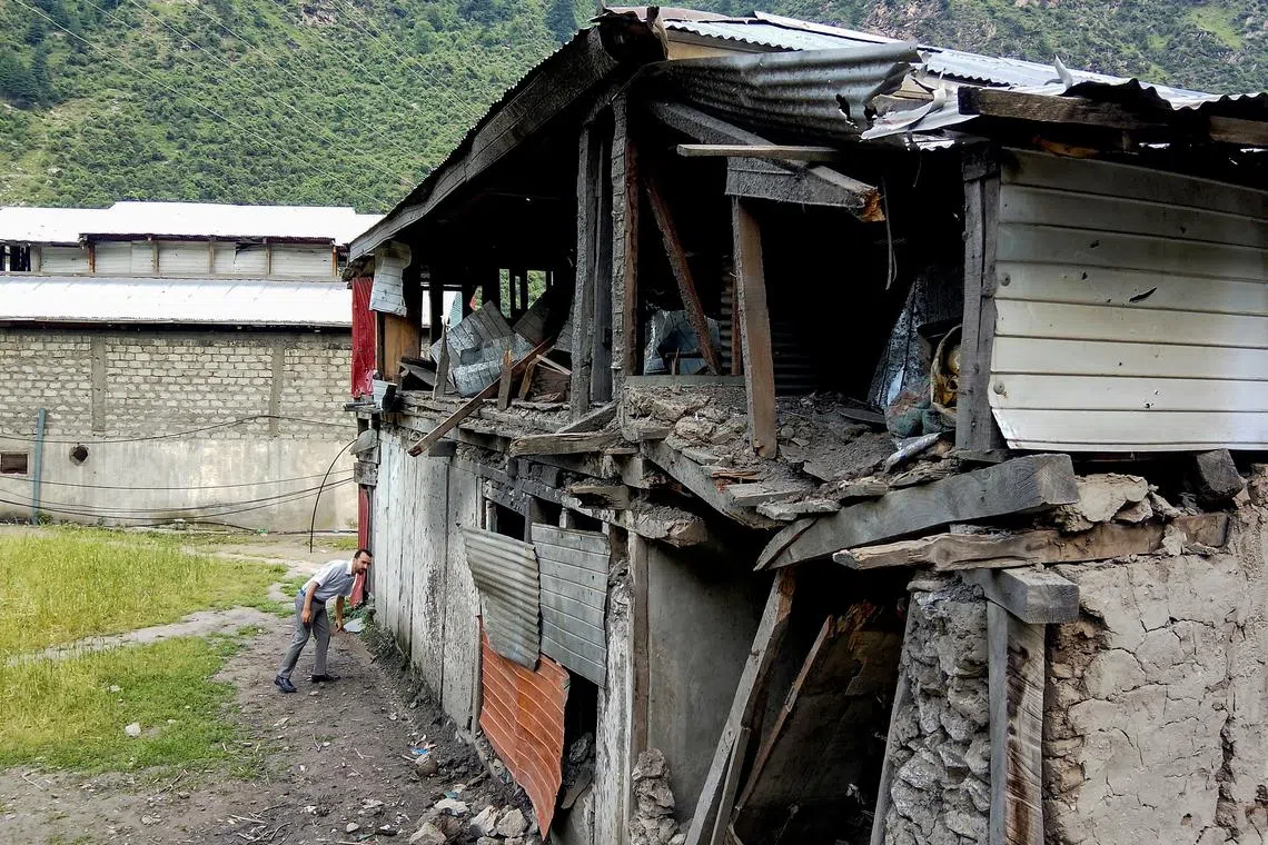 FILE PHOTO: A man assesses the damage of a house after it was hit in an Indian strike, following the ceasefire announcement between India and Pakistan, in Jura village in Neelum Valley, Pakistani Kashmir, May 12, 2025. REUTERS/Stringer/File Photo
