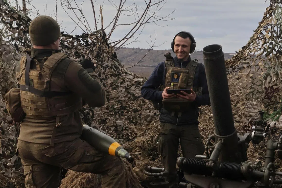 Ukrainian servicemen prepare a mortar for firing towards Russian troops, outside the front-line town of Bakhmut, in Ukraine's Donetsk region.