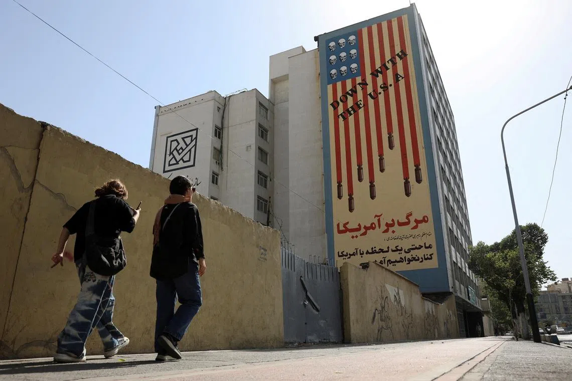 FILE PHOTO: People walk past an anti-US mural on a street in Tehran, Iran, June 5, 2025. Majid Asgaripour/WANA (West Asia News Agency) via REUTERS/File Photo