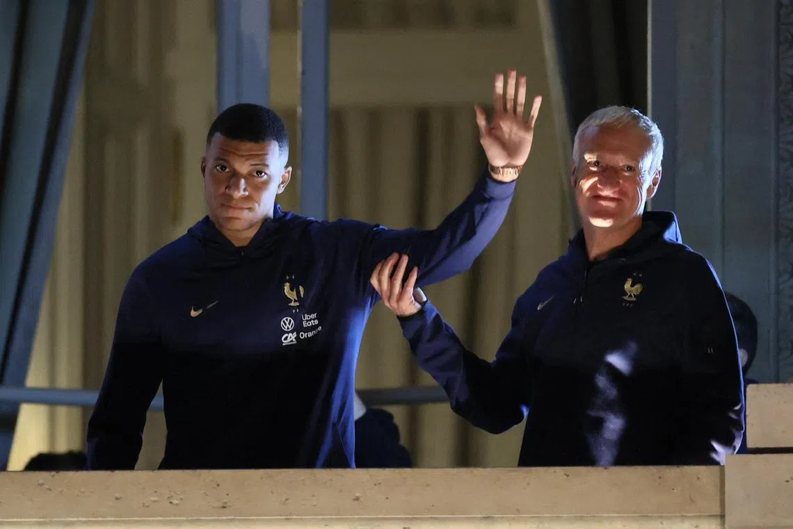 France's Kylian Mbappe and coach Didier Deschamps greet the fans from a balcony at Hotel Crillon after returning from their World Cup final loss to Argentina in Qatar.