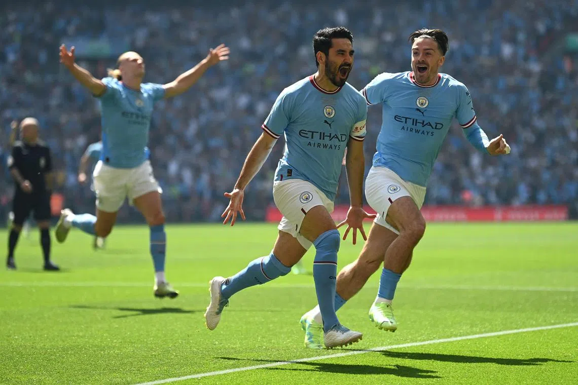 Manchester City's German midfielder Ilkay Gundogan (centre) celebrates after scoring with just 12 seconds on the clock.