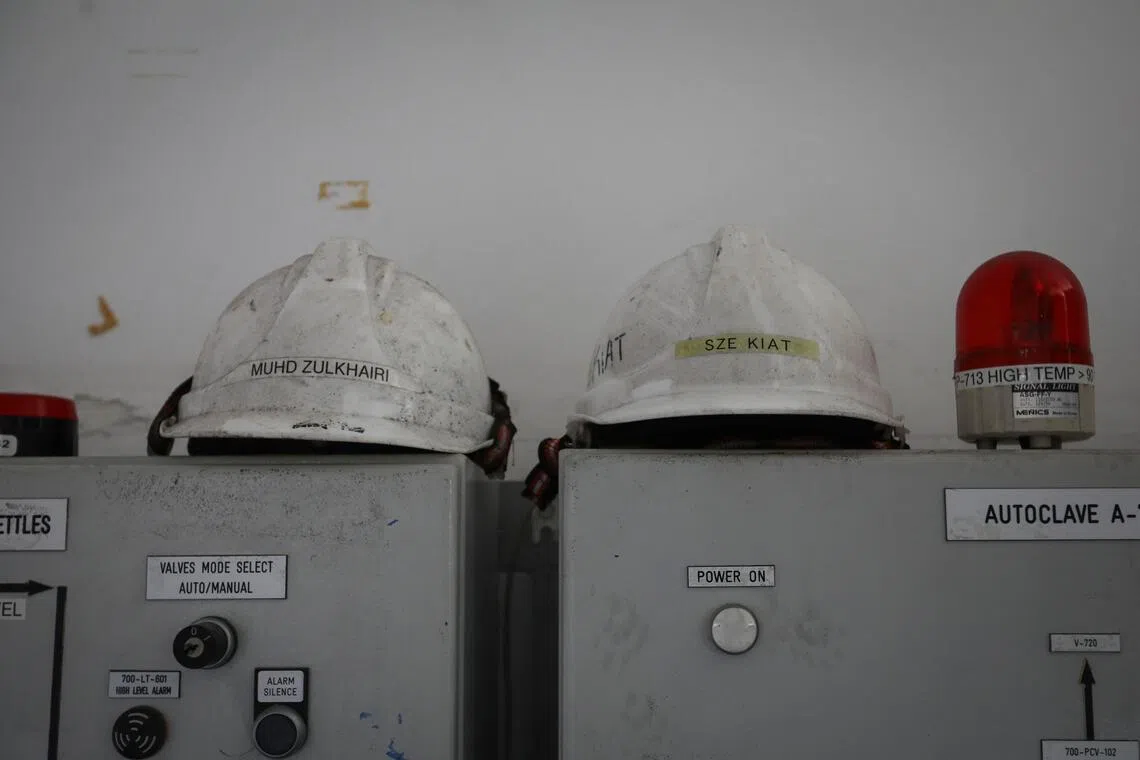 Safety helmets sit atop switch boxes in a control room. 