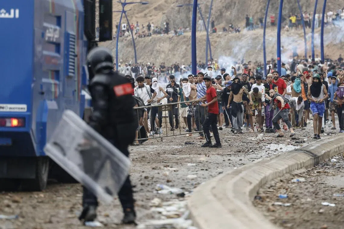 Moroccan security forces clash with migrants attempting to cross into Spain’s North African enclave of Ceuta on July 31.