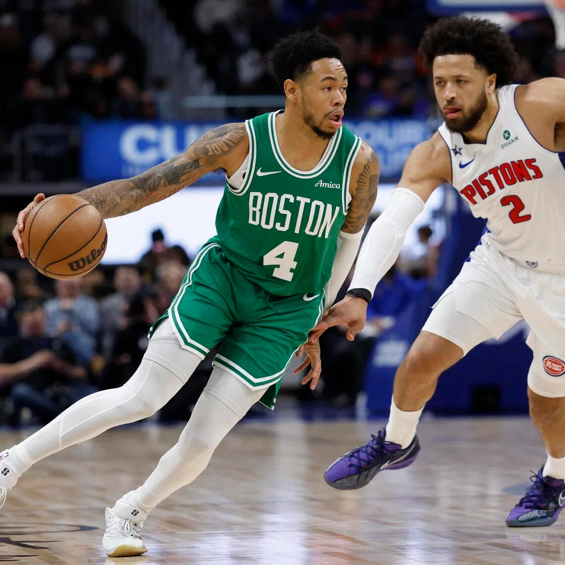 Boston Celtics guard Anfernee Simons dribbles the ball against Detroit Pistons guard Cade Cunningham in the first half at Little Caesars Arena. 