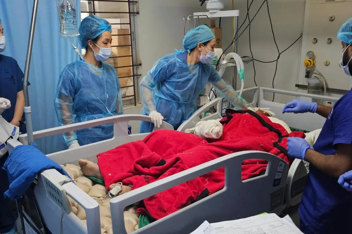 Dr Jolin Wong (left) and Dr Irene Wong from SGH's Department of Surgical Intensive Care checking on a burn patient in Dhaka.