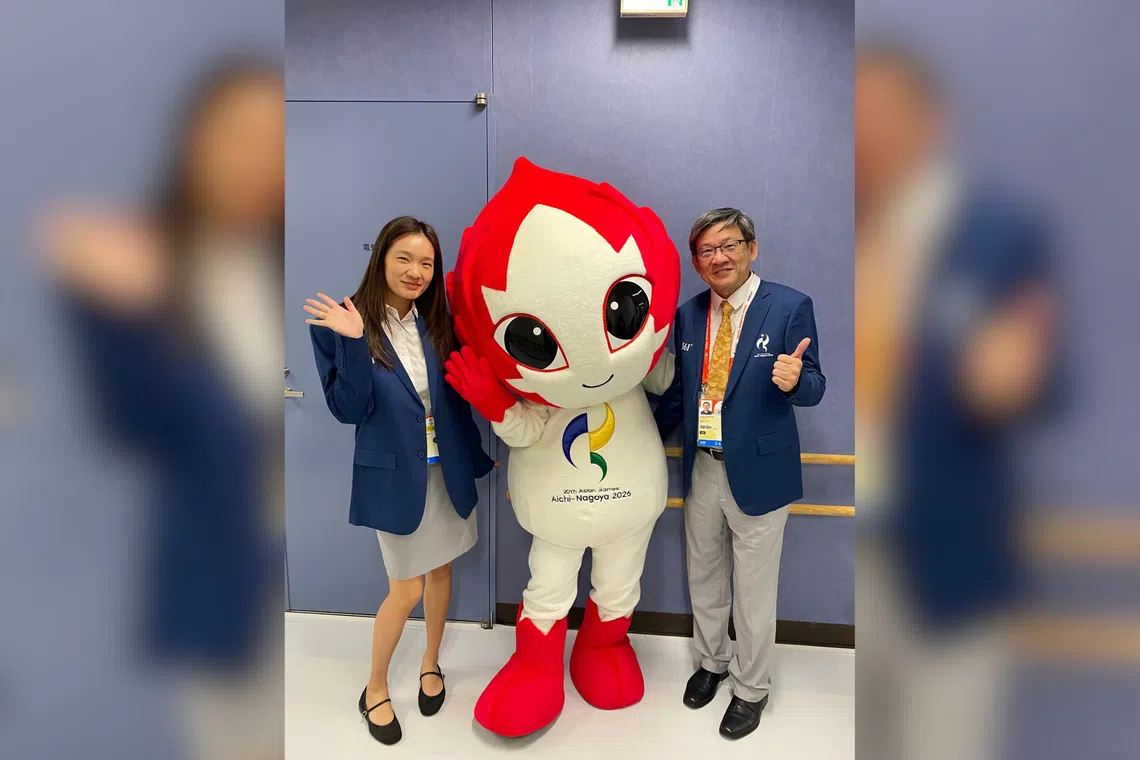 Geraldine Chew (left) and her father Steve posing with the Asian Games 2026 mascot Honohon at the Furuhashi Hironoshin Memorial Hamamatsu Swimming Centre.