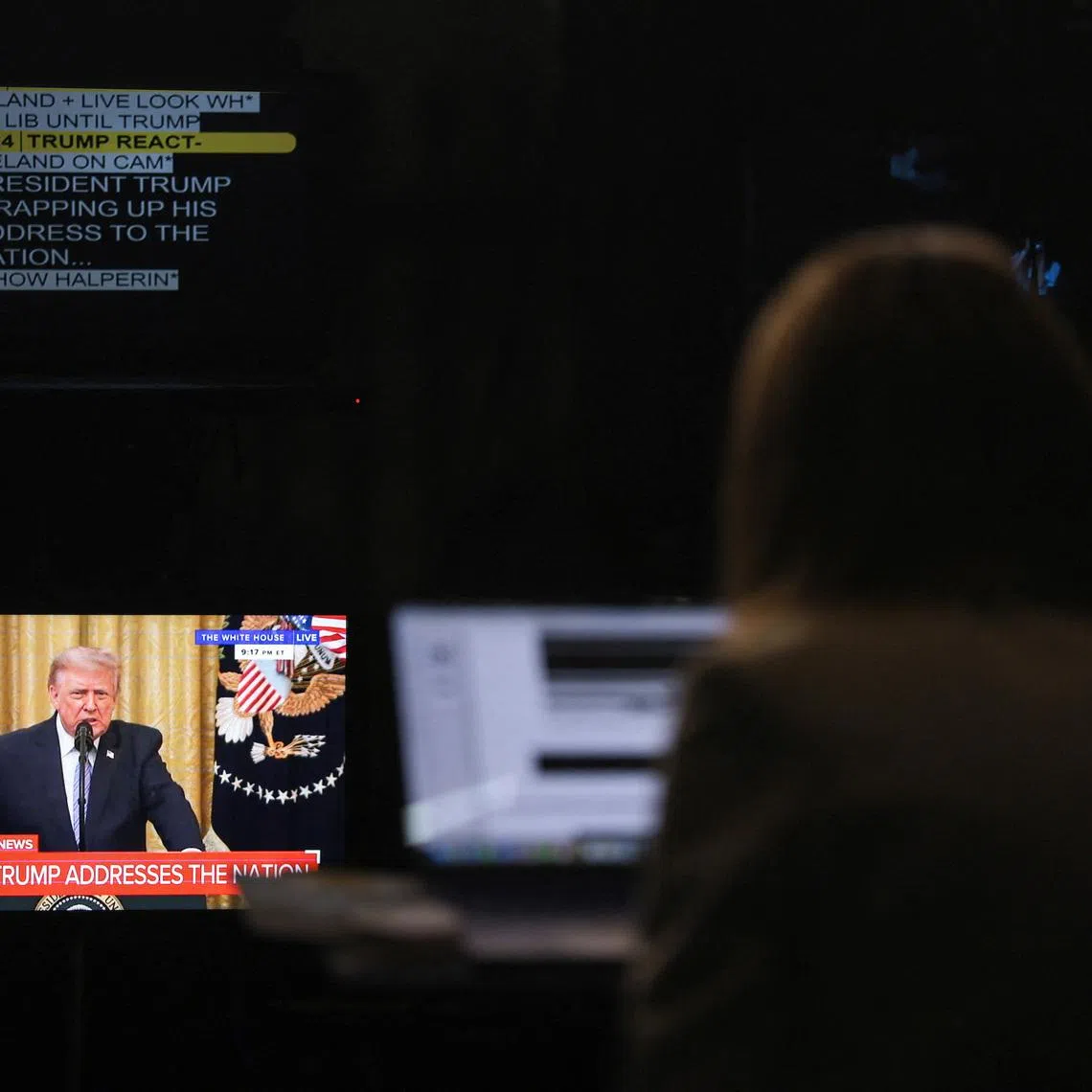 A journalist works as a screen displays U.S. President Donald Trump speaking about election security during an address to the nation from the East Room of the White House, in Washington, D.C., U.S., July 16, 2026. REUTERS/Kylie Cooper