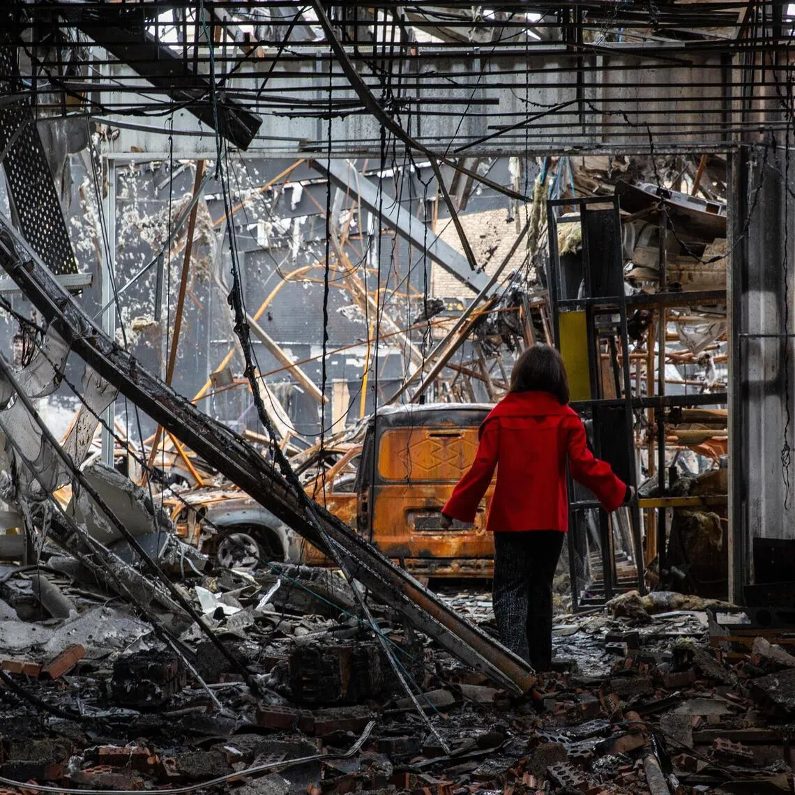 A girl steps through the ruins of an auto service center that was targeted by US-Israeli airstrikes in Tehran, Iran.