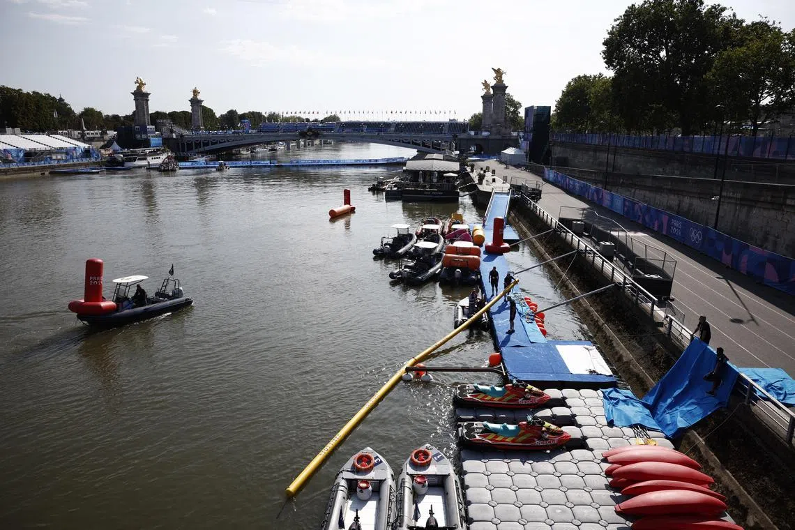 Paris 2024 Olympics - Triathlon - Alexander III Bridge, Paris, France - July 29, 2024. General view of the river Seine and Alexander III Bridge as workers remove a buoy after Triathlon training was cancelled amid water quality concerns REUTERS/Benoit Tessier