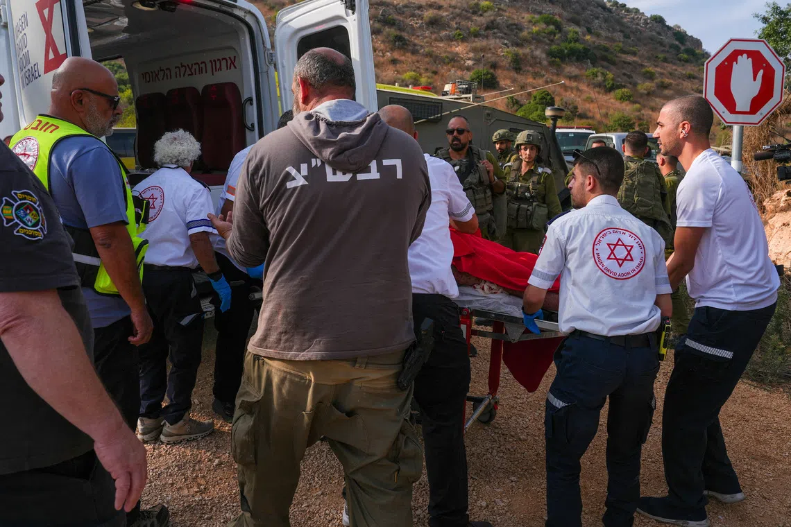 Israeli paramedics place a person on a stretcher in an ambulance, following an incident involving an explosion, near Kiryat Shmona, in northern Israel, October 12, 2026. REUTERS/Ayal Margolin