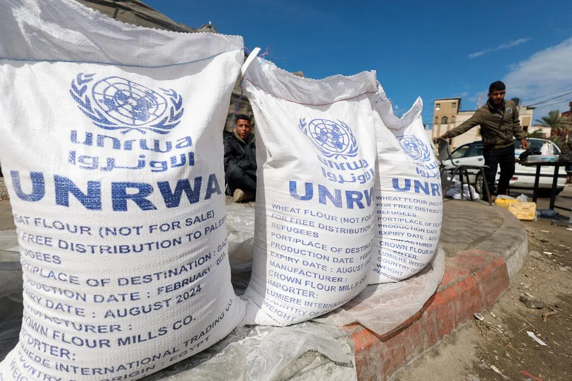 FILE PHOTO: Displaced Palestinians wait to receive United Nations Relief and Works Agency (UNRWA) aid, amid the ongoing conflict between Israel and the Palestinian Islamist group Hamas, in Rafah, in the southern Gaza Strip, March 7, 2024. REUTERS/Mohammed Salem/File Photo