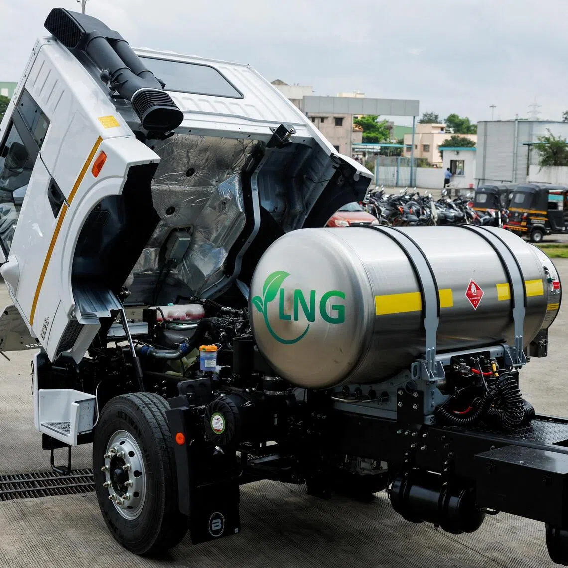 A man opens the hood of a Blue Energy 5528 liquefied natural gas (LNG) truck to check the engine at the manufacturing facility in Pune, India.