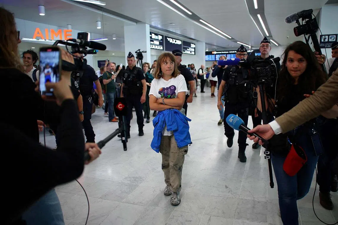 Swedish activist Greta Thunberg, walking inside a terminal surrounded by journalists and French police at the Paris-Charles de Gaulle Airport, in France, June 10, 2025. She departed Israel by plane on Tuesday after being detained aboard the Gaza-bound British-flagged yacht Madleen after Israeli forces boarded the charity vessel as it attempted to reach the Gaza Strip in defiance of an Israeli naval blockade.