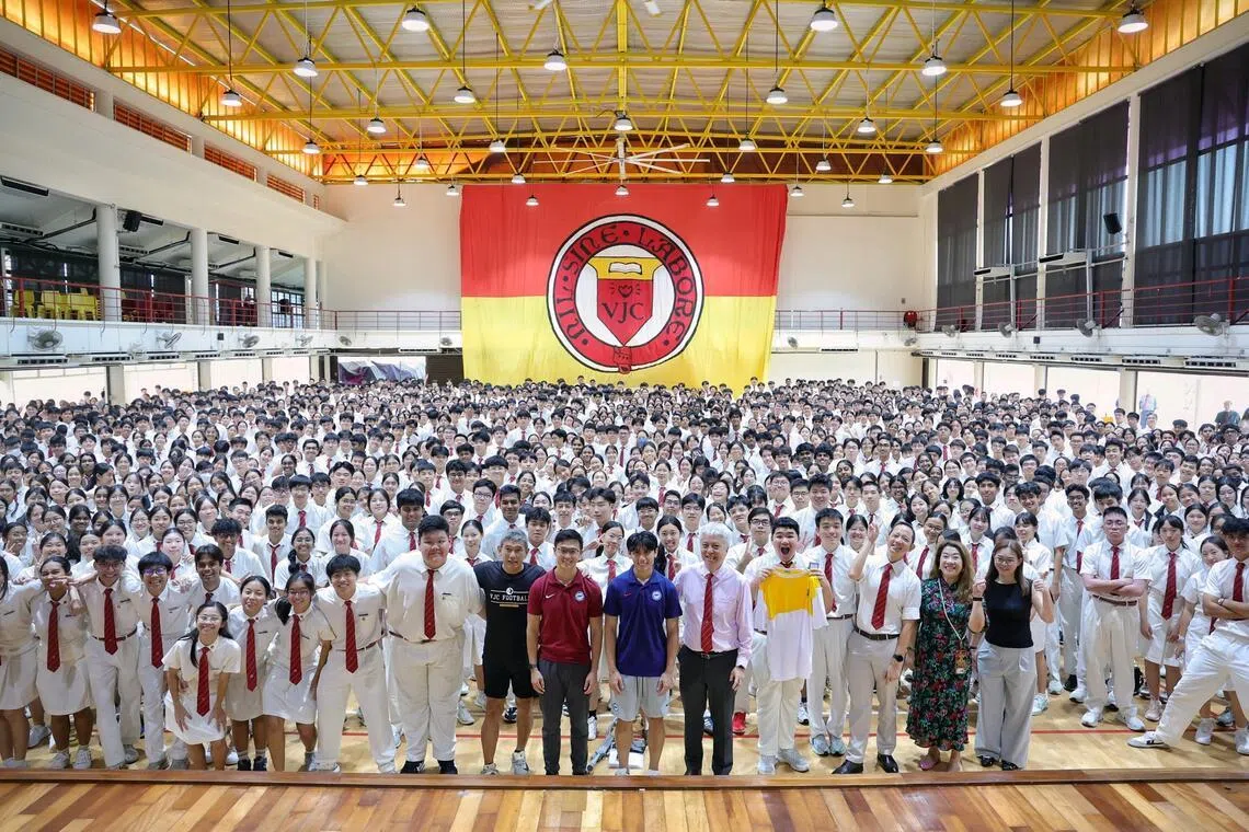 Lions head coach Gavin Lee (centre left) and winger Glenn Kweh (centre right) taking a group photo with students during an engagement session at Victoria Junior College on Feb 23.