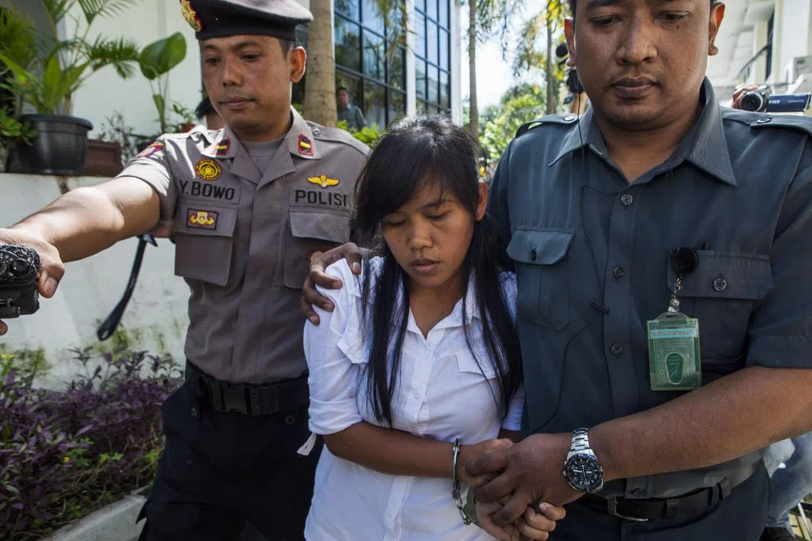 FILE PHOTO: Officers take the death row inmate of a drug case, Mary Jane Fiesta Veloso (C) of the Philippines, to her first judicial review trial in the District Court of Sleman, Yogyakarta, March 3, 2015. REUTERS/Ignatius Eswe/File Photo