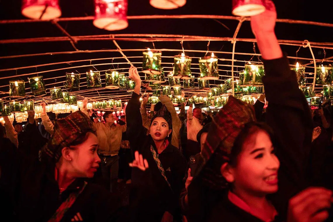 Participants preparing lanterns to attach to hot-air balloons with fireworks on the opening day of the week-long Tazaungdaing Lighting Festival in Taunggyi, Myanmar's northeastern Shan State, Nov 11, 2024.
