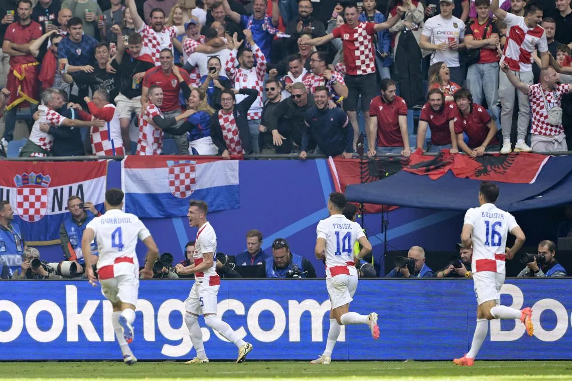 Croatia fans celebrate their team's second goal in the match against Albania, an own goal scored by Albania's Klaus Gjasula.