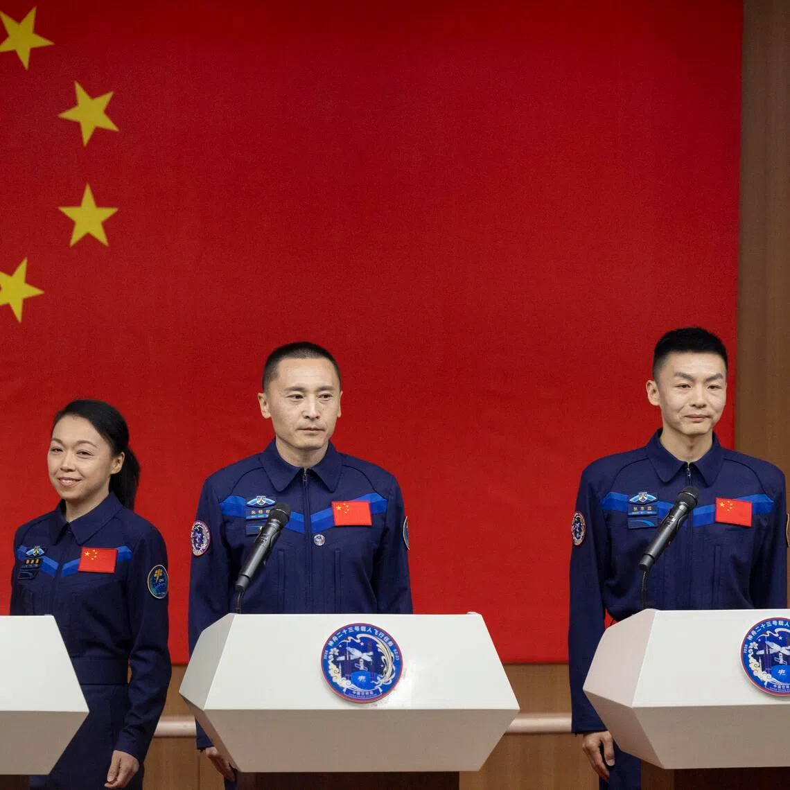 Astronauts of the Shenzhou-23 space mission (from left) Li Jiaying or Lai Ka-ying, Zhu Yangzhu and Zhang Zhiyuan, arriving at the press conference for the presentation of their mission on May 23, 2026. 