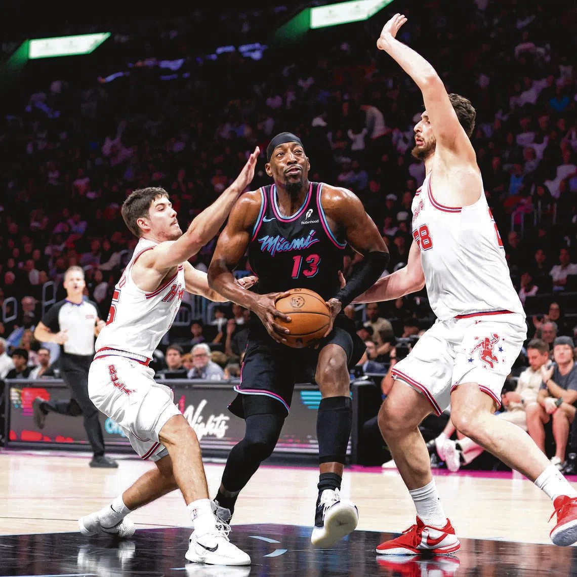 Bam Adebayo (centre) driving against Reed Sheppard (No. 15) and Alperen Sengun (No. 28) of the Houston Rockets on Feb 28, in Miami, Florida.