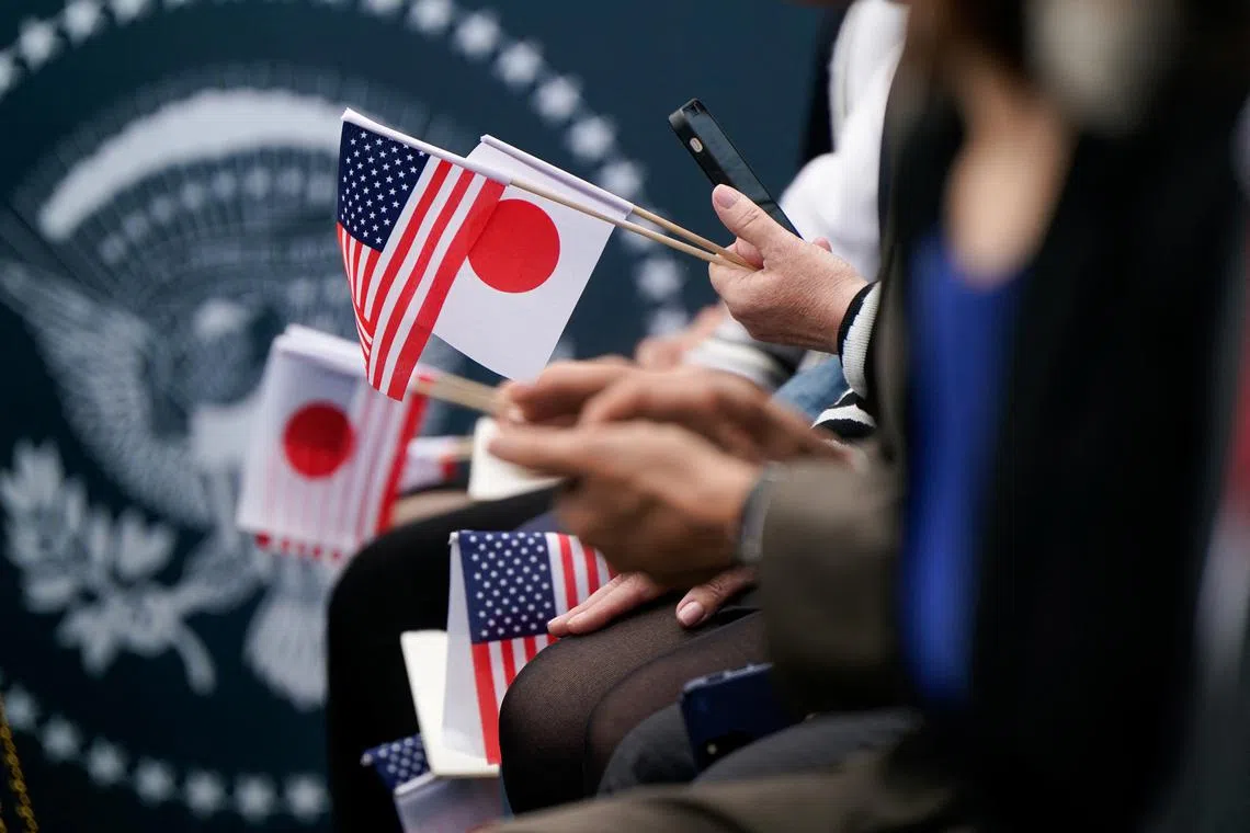 People hold Japan and U.S. flags on the day U.S. President Joe Biden meets Japanese Prime Minister Fumio Kishida and his spouse Yuko Kishida during an official White House State Arrival ceremony on the South Lawn of the White House in Washington, D.C., U.S., April 10, 2024. REUTERS/Elizabeth FrantzFrantz/File Photo