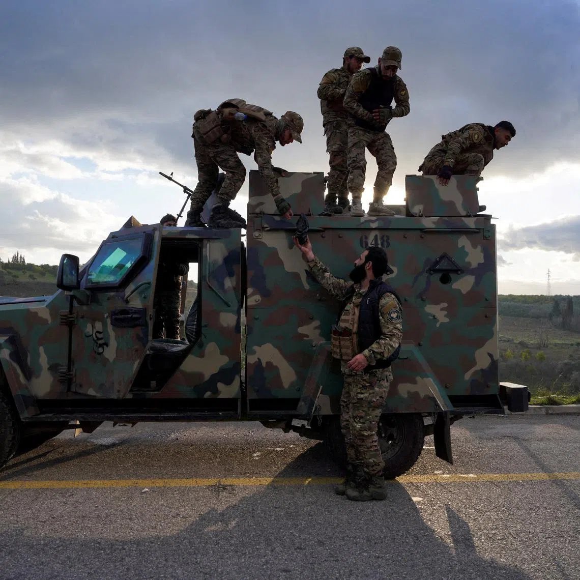 Members of the Syrian army stand on a military vehicle, as Syrian state agency, SANA, reported on Wednesday that the Syrian army sent reinforcements from Latakia to \"Deir Hafer front\", amid escalating tensions and threats from the Syrian government to launch an offensive against Kurdish-led Syrian Democratic Forces (SDF), in Latakia, Syria, January 14, 2026. REUTERS/Karam al-Masri