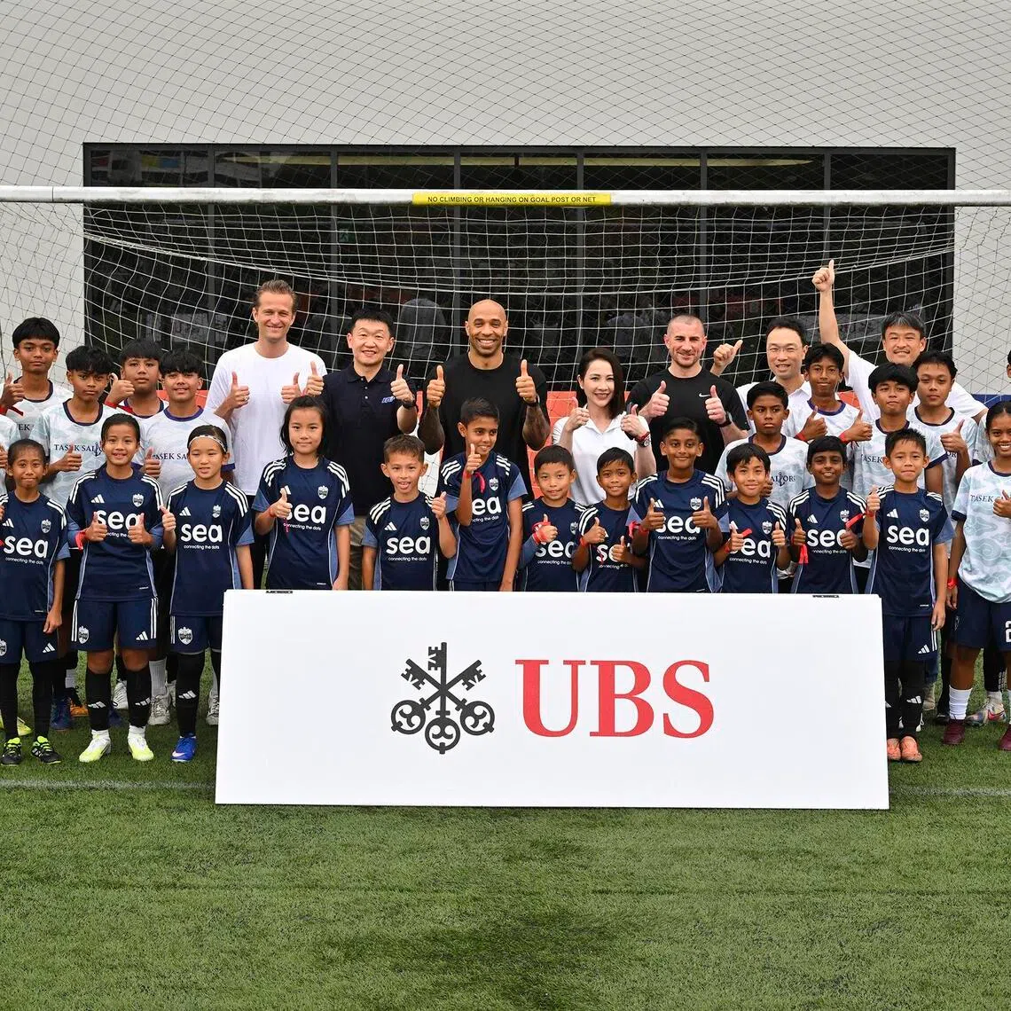 Thierry Henry (centre) in a group photo taken with kids from the Lion City Sailors' academy and Tasek Football Academy, at a UBS event at the Sailors' training centre on May 25.