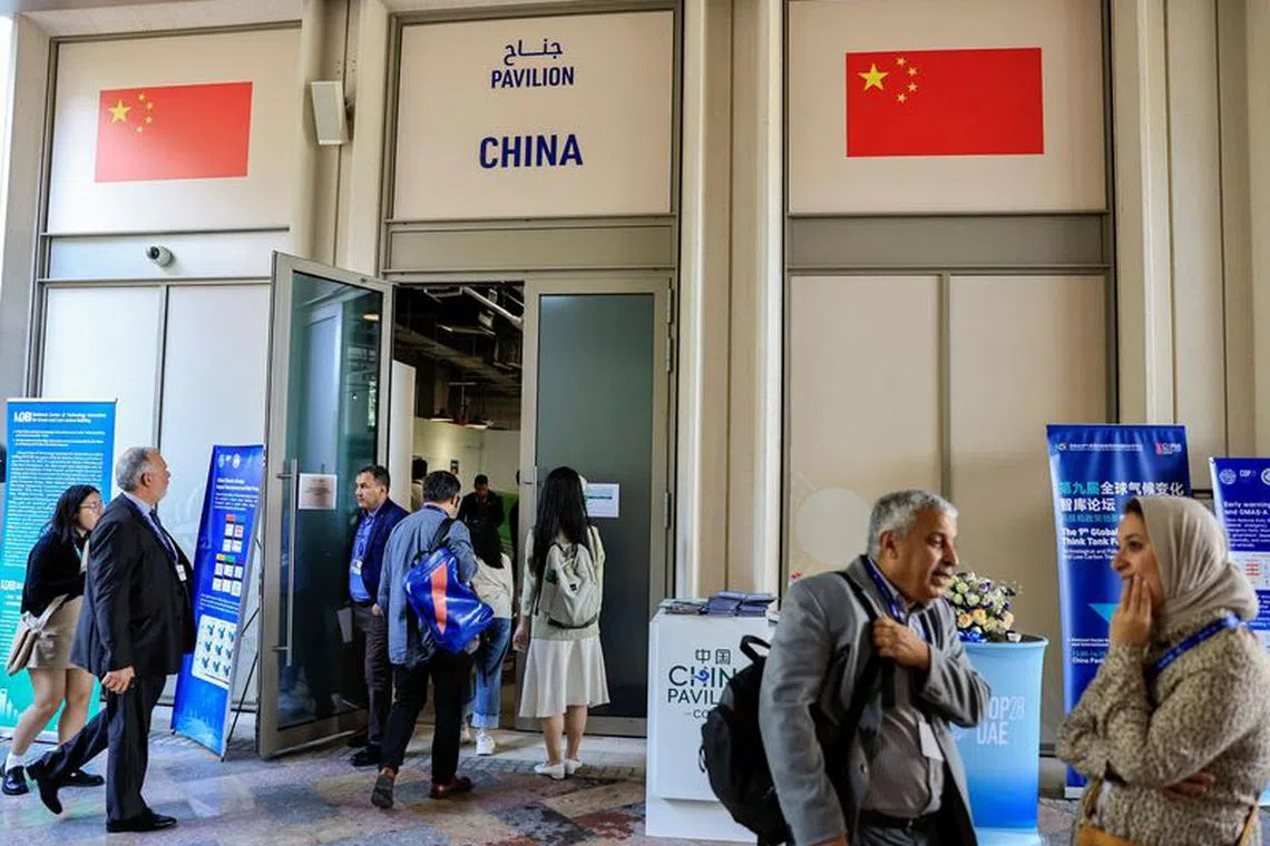 FILE PHOTO: People stand outside the China Pavilion at the United Nations Climate Change Conference COP28 in Dubai, United Arab Emirates, December 6, 2023. REUTERS/Thaier Al-Sudani/File Photo